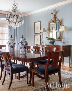 a dining room table with blue chairs and a chandelier