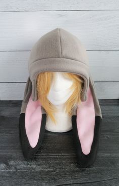 a white mannequin head wearing a gray and pink bunny ears hat