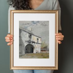 a woman holding up a painting in front of her face, with the frame open