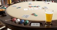 a table that has some cards on it and a beer in front of the table