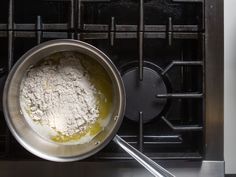 a pan filled with flour sitting on top of a stove next to an oven burner