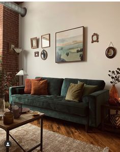 a living room filled with furniture and pictures hanging on the wall above a coffee table