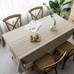 a table with four chairs and a vase on it