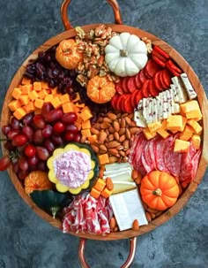 a wooden platter filled with assorted meats and cheeses on a metal stand