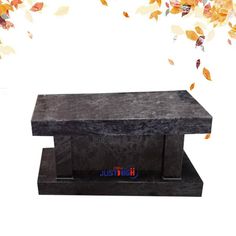 a black marble bench with autumn leaves coming out of the top and on it's sides