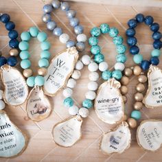 several different types of beaded necklaces on a wooden table with words written on them