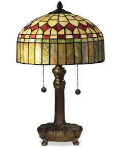 a lamp that is sitting on top of a wooden stand with a glass shade over it