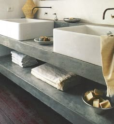 two white sinks sitting on top of a wooden counter