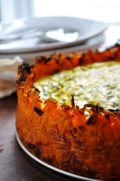 a close up of a cake on a table with plates and utensils in the background