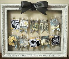 a white frame with pictures hanging from it's sides and a black bow on the top