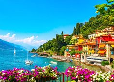 colorful houses and boats on the water with mountains in the background