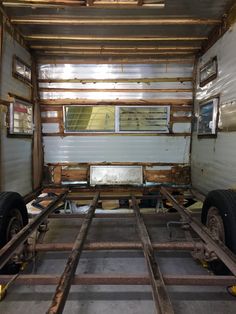 the inside of a truck with some wood planks on the floor and two large tires