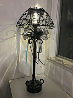 a lamp that is sitting on top of a shelf in front of a window,