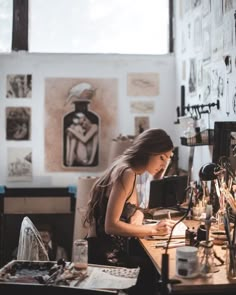 a woman sitting at a desk in an art studio