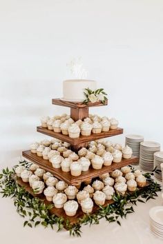 a three tiered cake with cupcakes on it