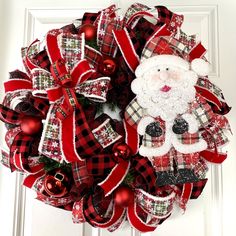 a red and black wreath with a santa clause on it