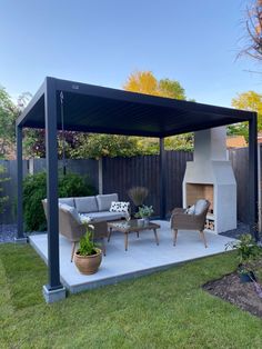 an outdoor living area with furniture and a fire place in the middle of the yard