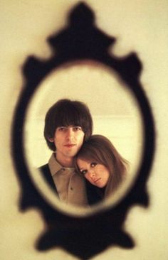 a man and woman are looking through a magnifying glass to see their reflection