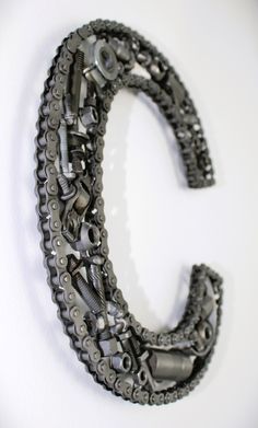 the letter c is made out of bicycle chains and gears on a white background with space for text