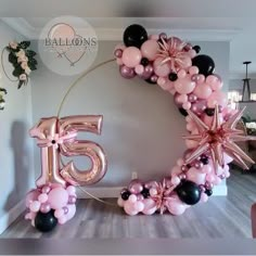 a balloon arch with the number fifteen five in pink, black and white balloons hanging from it