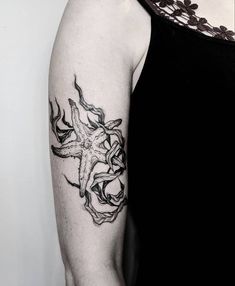 a black and white photo of a woman's arm with an octopus tattoo on it