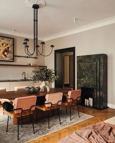 a dining room table with six chairs and a chandelier hanging from the ceiling