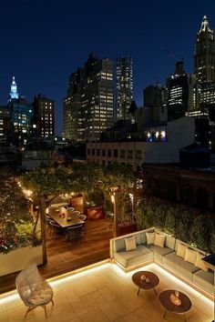 an outdoor seating area with city lights in the background