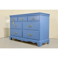 a blue dresser with gold handles and knobs