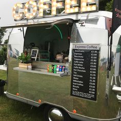 a food truck parked in the grass with a sign that says coffee on it's side