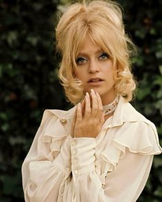 a woman with blonde hair wearing a white blouse