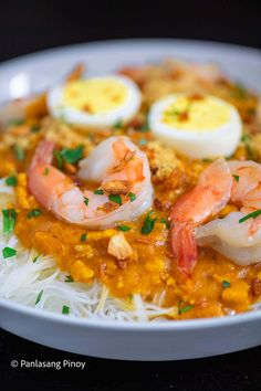 a white plate topped with rice and shrimp