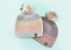 two crocheted hats with pom - poms on them sitting side by side