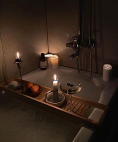 a candle is lit in the middle of a bathtub with soap and candles on it