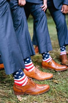 three men in suits and ties with american socks on their feet, one wearing a pair of brown shoes