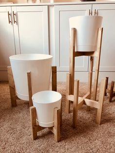 three white buckets sitting on top of a carpeted floor next to wooden chairs