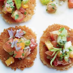 small appetizers are arranged on top of each other, including tomatoes and cucumbers