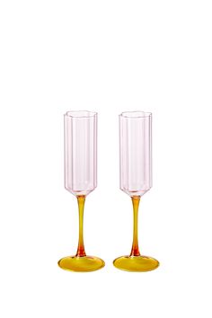 two yellow wine glasses sitting next to each other