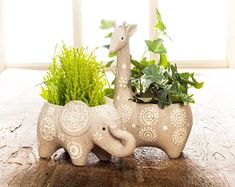 an elephant and giraffe planter sitting on a table