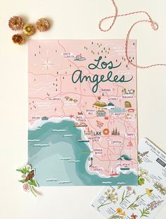 a map of los angeles with the name and cities on it next to some flowers