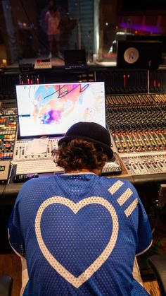 a person sitting in front of a mixing desk with a laptop on it's lap