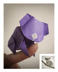 an origami elephant is held up in front of a white background with the image of a mouse on it