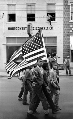 black and white photograph of men carrying an american flag