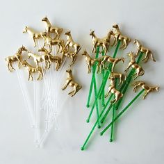 small gold horses on green sticks are sitting next to each other, and one is in front of them