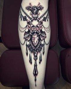 a woman's leg with an intricate tattoo on it