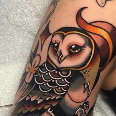 an owl tattoo on the arm and leg is shown in black and grey colors with orange accents