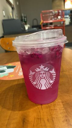 a plastic cup filled with liquid sitting on top of a wooden table