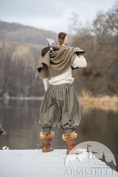 a man standing on the edge of a body of water with his back to the camera