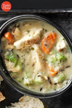 a bowl of chicken and vegetable soup with bread