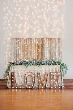 an illuminated love sign on top of a wooden table