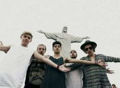 a group of young men standing next to each other in front of a jesus statue